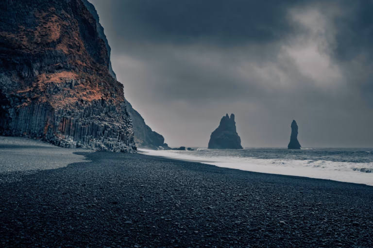 Czarna plaża Reynisfjara na Islandii ze skałami Reynisdrangar w pochmurny dzień